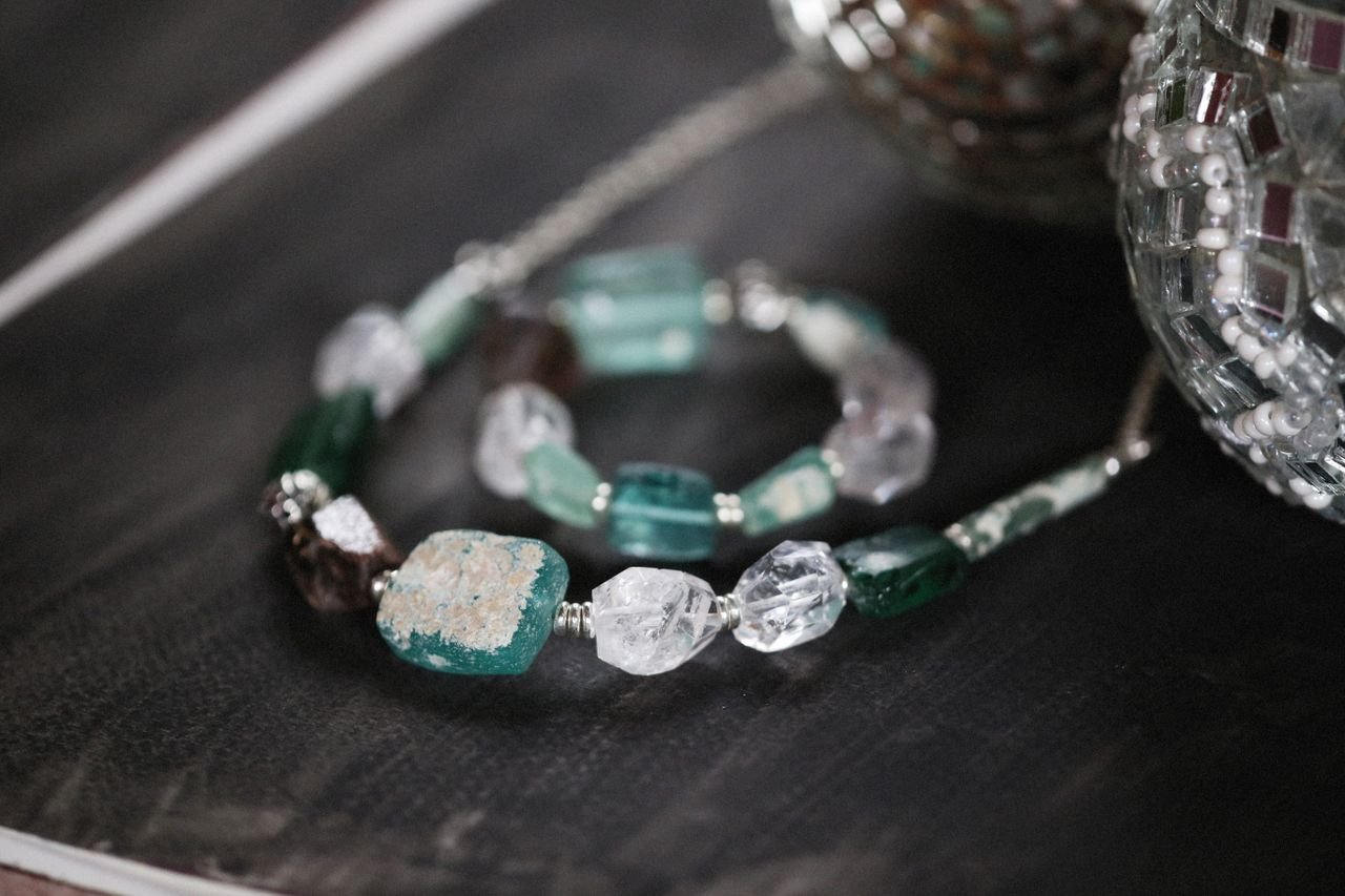 Handmade gemstone bracelet with rough stones shimmering in a stylish, artistic setup.